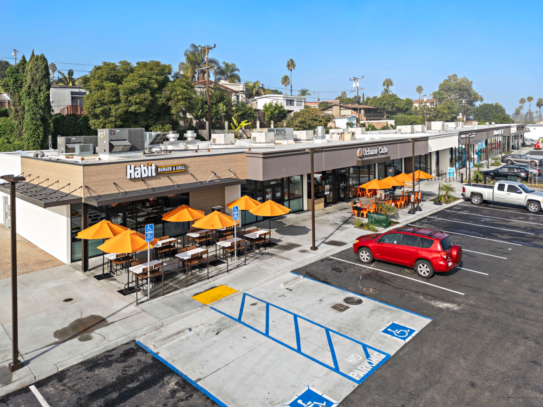 Aerial view of a multi-tenant retail center with Habit Burger & Grill and Urbane Cafe